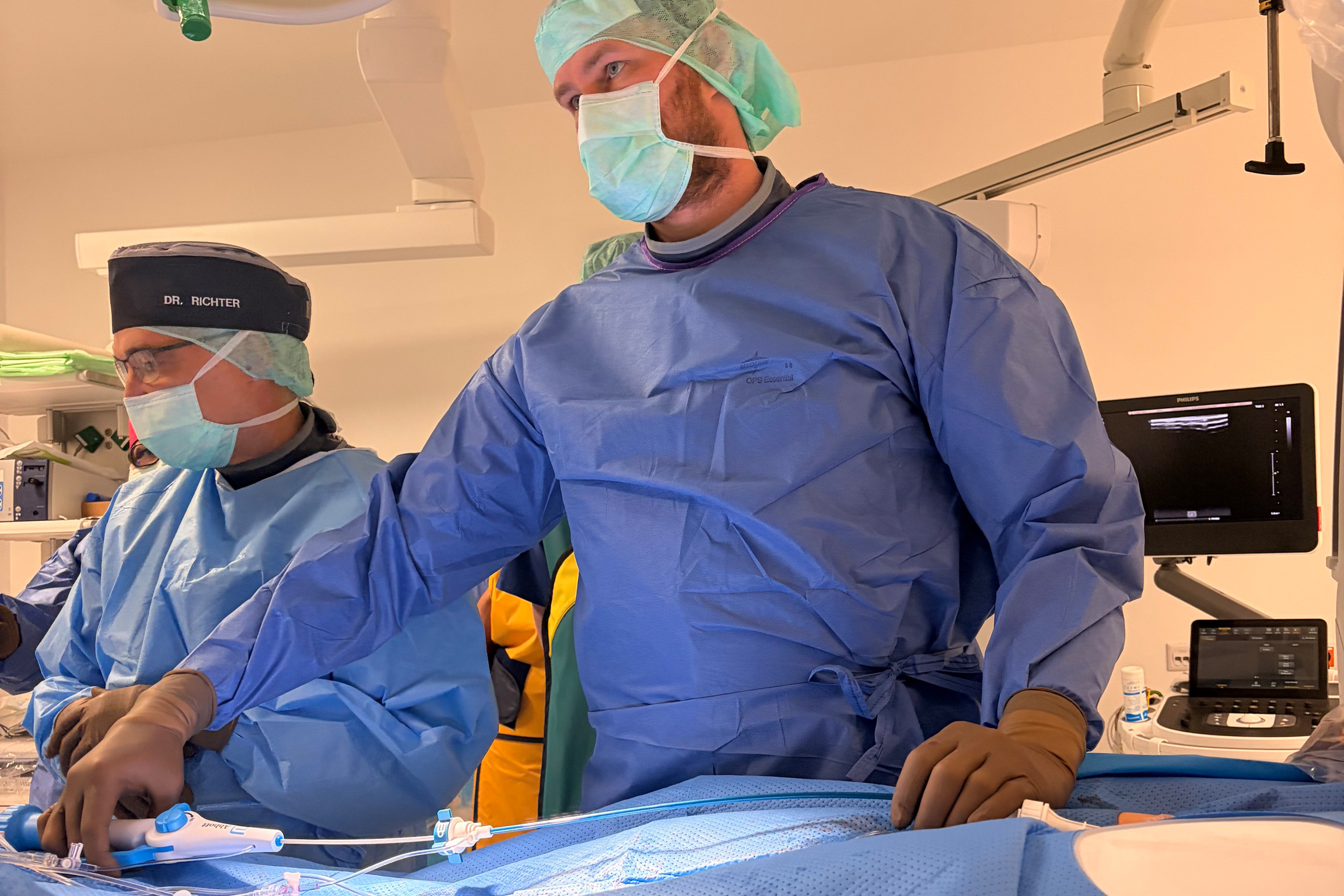 Zwei Männer in OP-Kleidung operieren.