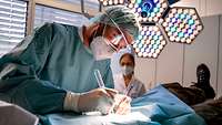 Kliniken des Bundeswehrkrankenhaus Ulm Arzt mit Maske und OP-Besteck mit Beleuchtung