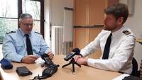 Zwei Soldaten sitzen an einem Tisch und unterhalten sich
