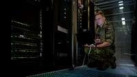 Administrator am Laptop vor einem Server für das Klinische-Informations-Managment des Bundeswehrkrankenhaus Ulm