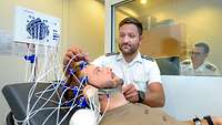 Einem Patienten werden am Kopf Sensoren für ein Elektroenzephalogramm (EEG) angelegt