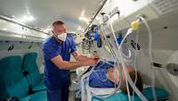 Ein Krankenpfleger der Intensivstation bereitet einen Patienten in der Druckkammer für die Sauerstoff-Überdrucktherapie vor