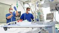 Krankenpfleger betreuen einen Patienten auf der Intensivstation vom Bundeswehrkrankenhaus Ulm Zwei Krankenpfleger betreuen einen Intensivpatienten auf der Intensivstation am Bundeswehrkrankenhaus Ulm