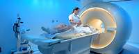 Medizinisch-technische Radiologieassistentin bereitet einen Patienten für eine Magnetresonanztomographie (MRT) vor Medizinisch-technische Radiologieassistentin steht neben einem Patienten zur Vorbereitung eines MRT