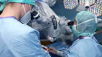 Operation in der Klinik für Neurochirurgie mithilfe eines Mikroskopes