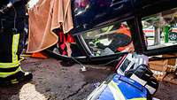 Ein zu versorgender Patient liegt kopfüber in einem verunfallten Auto