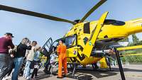 Besucher stehen an, um einen Blick in die Pilotenkabine des ADAC-Rettungshubschraubers „Christoph 23“ zu werfen.
