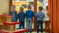 Kinder schauen aus einem Fenster und sehen einen Rettungswagen