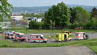 Mehrere Krankenwagen von verschiedenen Organisationen stehen auf einem großen Platz.