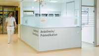 Eine Person läuft an einer Anmeldung im Anästhesiebereich vorbei