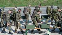 Mehrere Soldaten nehmen Obst zum Verpflegen bei einem Marsch auf