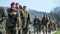 Ein Soldat zeigt mit seinem Zeigefinger auf das Hoheitsabzeichen seiner Feldbluse