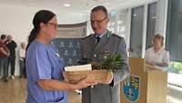 Ein Mann überreicht einer Frau einen Korb mit Obst