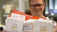 Eine Person überreicht den Präsentkorb