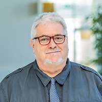 Ein Mann mit grauen Haaren und kurzem grauen Bart