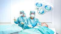 Eine Ärztin behandelt eine Patientin am Operationstisch. Im Hintergrund ist eine weitere Person mit Chirurgischen Instrumenten.