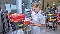 Eine Apothekerin prüft einen Rettungsrucksack