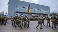 Eine militärische Formation marschiert auf einem Appellplatz