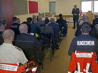 In einem Veranstaltungsraum sitzen Rettungssanitäter und ein Dozent