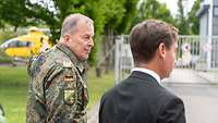 Ein Soldat und ein Mann in Anzug laufen nebeneinander