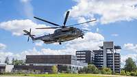 Transporthubschrauber bei der Landung im Hintergrund das Bundeswehrkrankenhaus Ulm